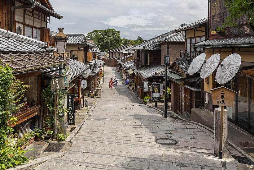 Pedestrian road with pavements, paper umbrellas and people in yukata, Higashiyama-ku, Kyoto, Japan