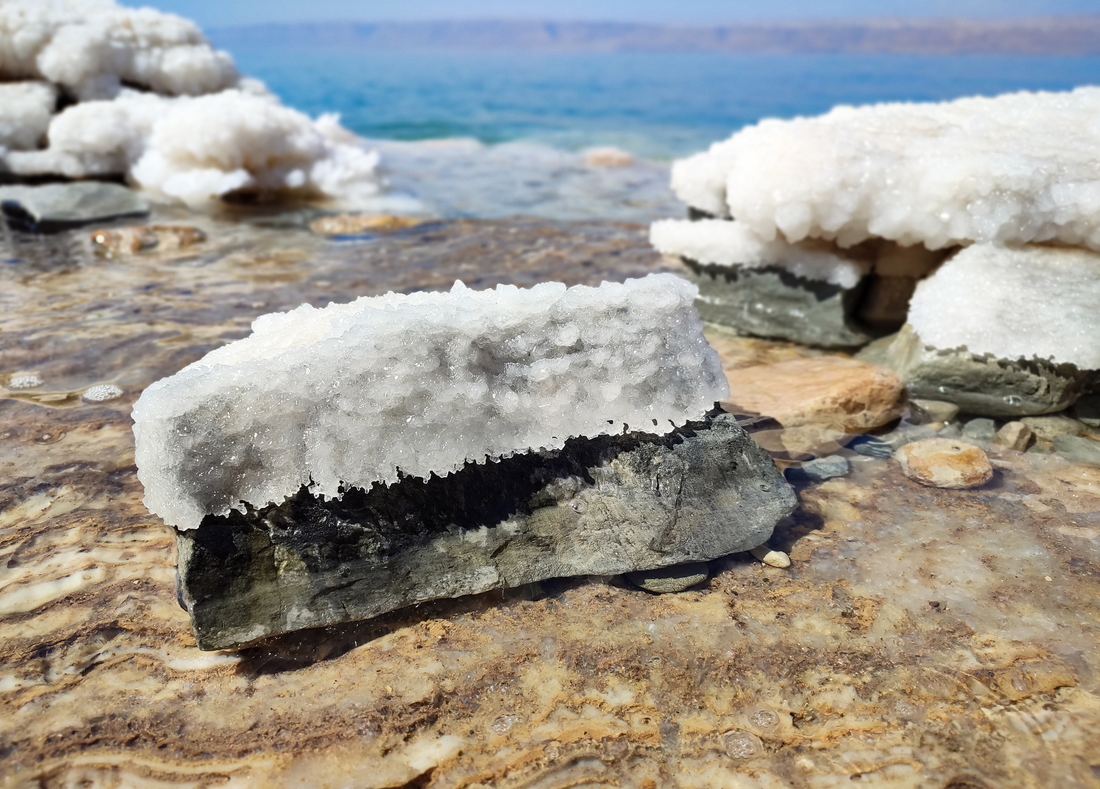 White salt crystals forming in shallow water along the Dead Sea shore